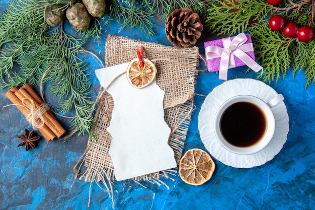 Vista superior abrió cuaderno ramas de abeto conos juguetes de árbol de Navidad en superficie azul