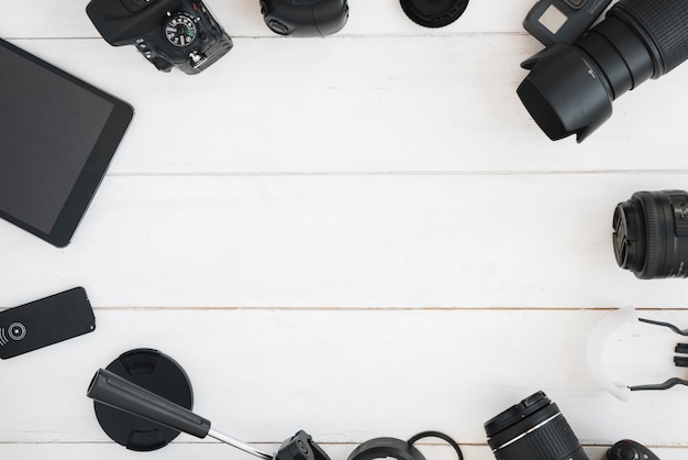 Foto gratuita vista superior de accesorios de fotografía profesional en mesa de madera blanca.