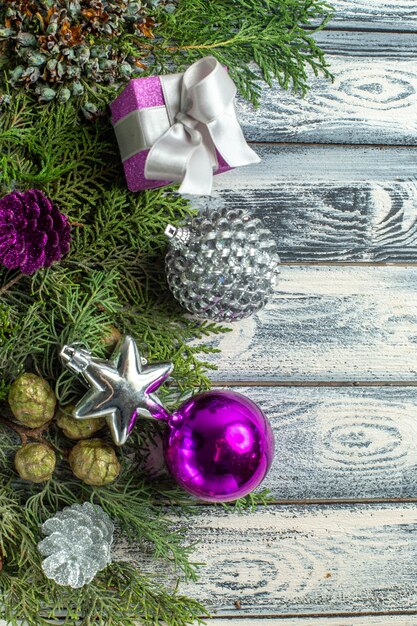 Vista superior adornos navideños regalo pequeño ramas de abeto juguetes navideños en superficie de madera