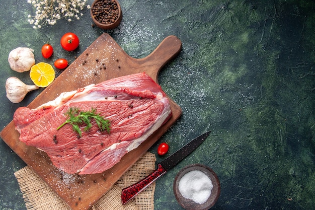 Foto gratuita vista superior de ajos de carne roja cruda fresca en tabla de cortar de madera limón en cuchillo de flor de toalla de color desnudo en el lado derecho sobre fondo de color mezclado