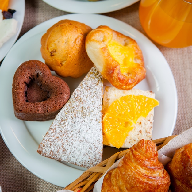 Vista superior al horno con rodaja de naranja y forma de corazón en plato blanco