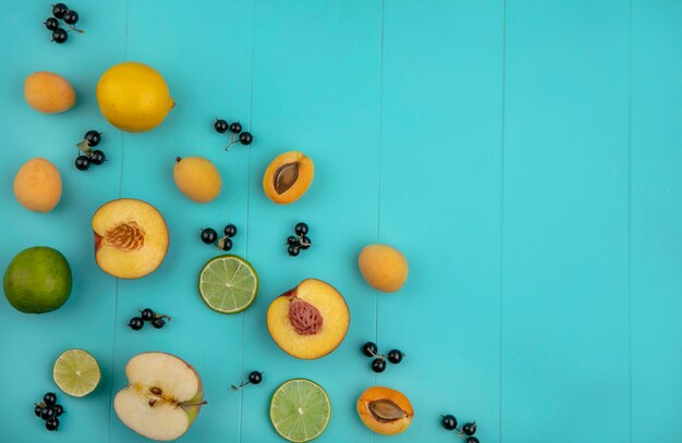 Vista superior de albaricoques con manzanas limón con grosella negra con rodajas de limón sobre una superficie azul claro