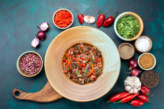 Vista superior de alimentos de carne vegetal en rodajas junto con cebollas verdes ajos en la mesa oscura comida condimento vegetal