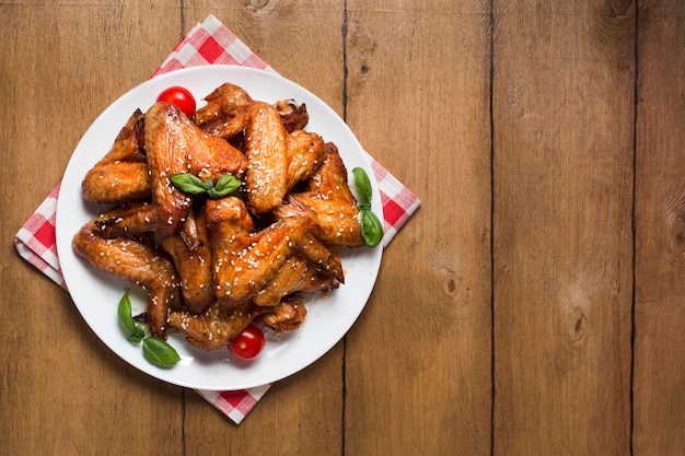 Vista superior de alitas de pollo en un plato con semillas de sésamo y espacio de copia