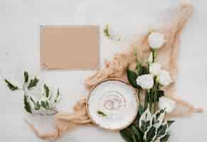 Foto gratuita vista superior anillos de boda con flores sobre la mesa