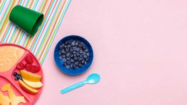 Vista superior de arándanos y comida para bebés con espacio de copia