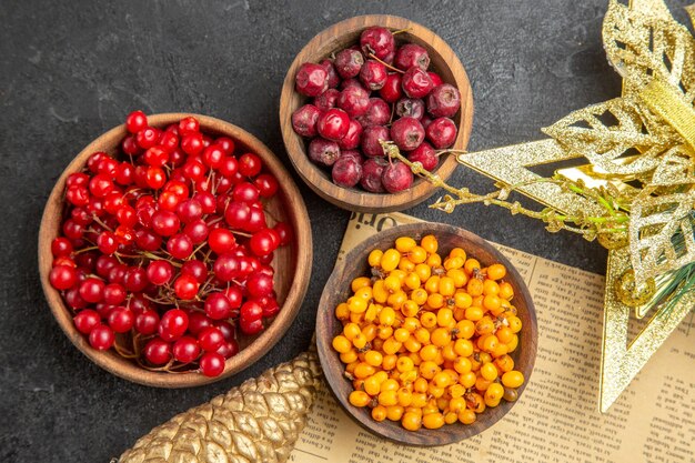 Vista superior de arándanos rojos frescos con otras frutas sobre fondo oscuro