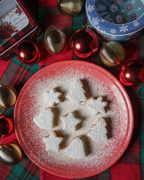 Vista superior del árbol de Navidad, campana y galletas estrella cubiertas con azúcar en polvo