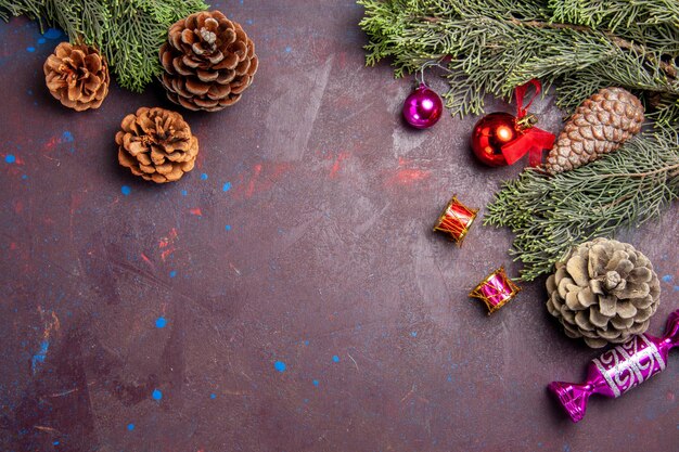 Vista superior del árbol de navidad con conos y juguetes en el espacio oscuro