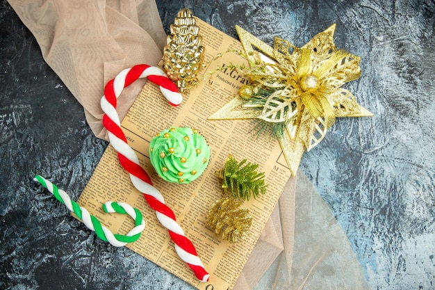 Vista superior del árbol de Navidad de la magdalena dulces de Navidad adornos de Navidad en el periódico mantón beige sobre una superficie oscura