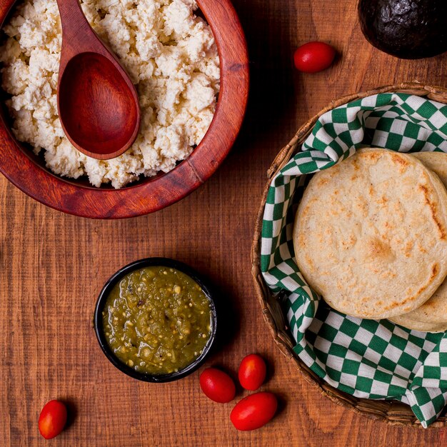 Vista superior de arepas en canasta con salsa