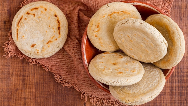 Vista superior de arepas en un recipiente con un paño