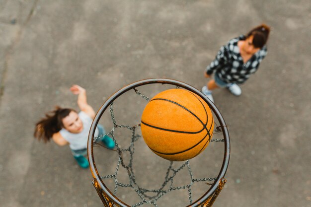 Vista superior con aro de chicas jugando al baloncesto