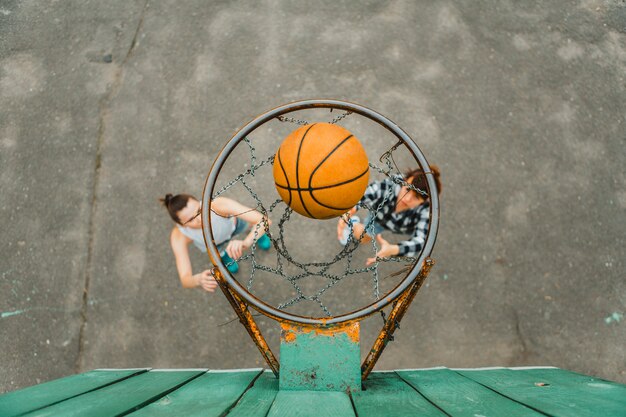 Vista superior con aro de chicas jugando al baloncesto