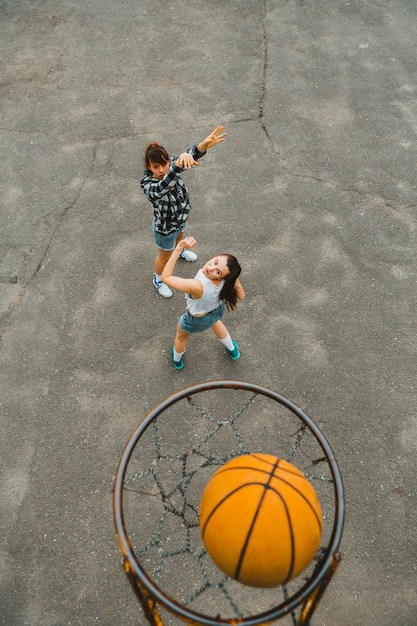 Vista superior con aro de chicas jugando al baloncesto