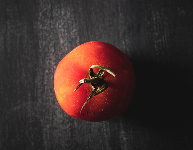 Vista superior arreglo con tomate sobre fondo negro