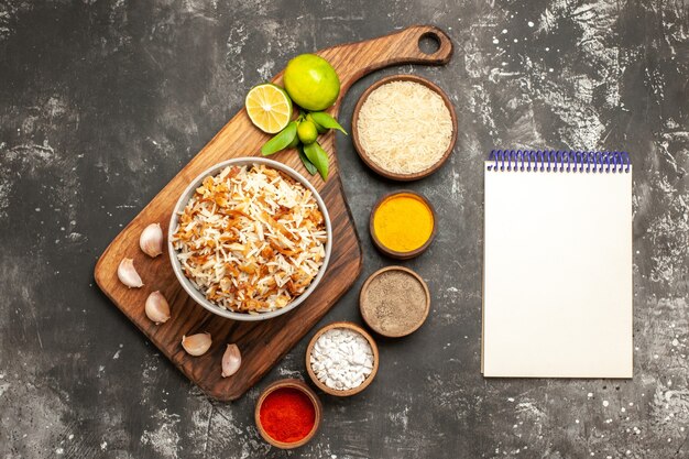 Vista superior de arroz cocido con condimentos en la comida de superficie oscura plato oscuro comida oriental