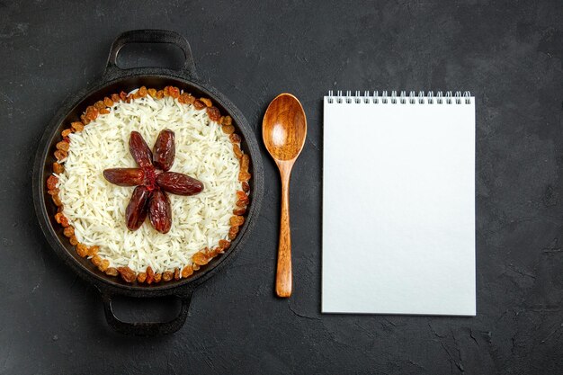 Vista superior de arroz cocido con condimentos y pasas en superficie oscura comida comida arroz cena oriental