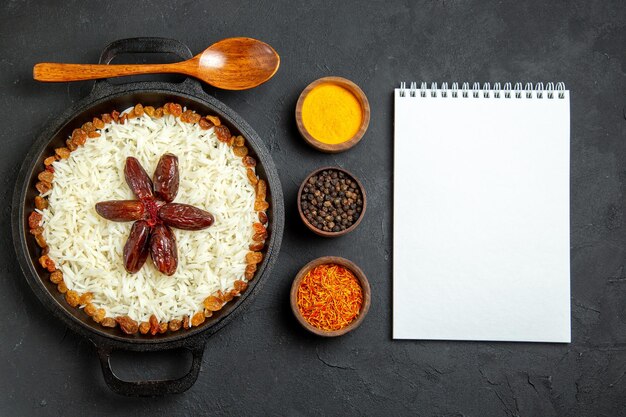 Vista superior de arroz cocido con condimentos y pasas en superficie oscura comida comida arroz cena oriental