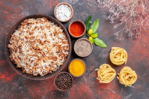 Vista superior de arroz cocido con condimentos en un plato de comida de piso oscuro comida oscura