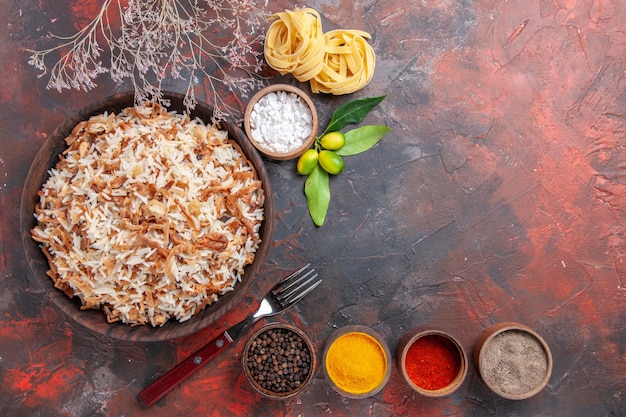 Vista superior de arroz cocido con condimentos en la superficie oscura comida oscura foto plato comida