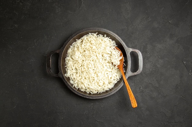 Vista superior arroz cocido dentro de la sartén en la superficie oscura cena comida comida arroz oriental