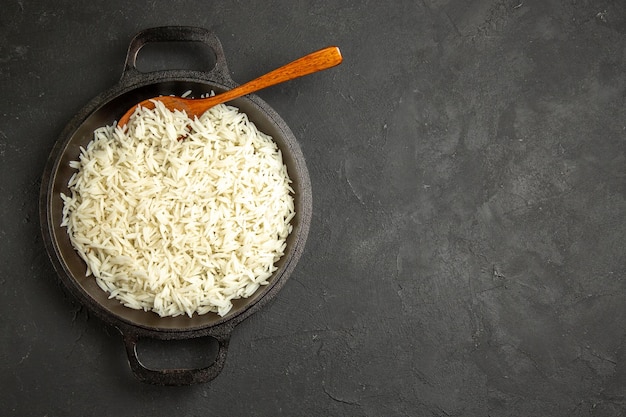 Vista superior arroz cocido dentro de la sartén en la superficie oscura cena comida comida arroz oriental