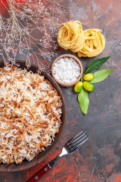 Vista superior de arroz cocido con rebanadas de masa en un piso oscuro plato de comida oscura comida