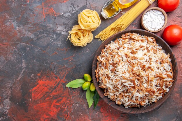 Vista superior de arroz cocido con rebanadas de masa en un plato de superficie oscura comida oscura comida