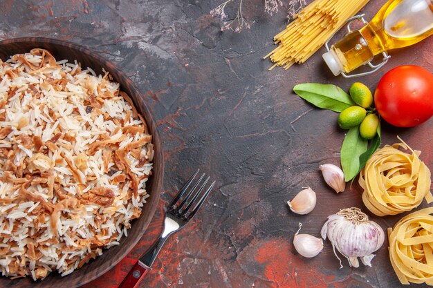 Vista superior de arroz cocido con rebanadas de masa en la superficie oscura comida plato foto comida oscura