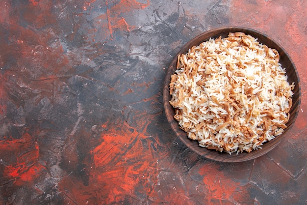 Vista superior de arroz cocido con rodajas de masa en el plato de escritorio oscuro comida pasta de comida oscura