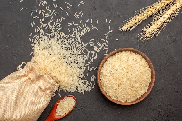 Vista superior del arroz crudo dentro de la bolsa y el plato sobre una superficie gris