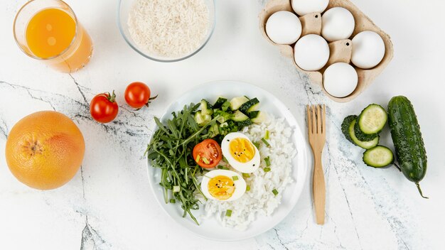 Vista superior de arroz y huevos en un plato con jugo de naranja