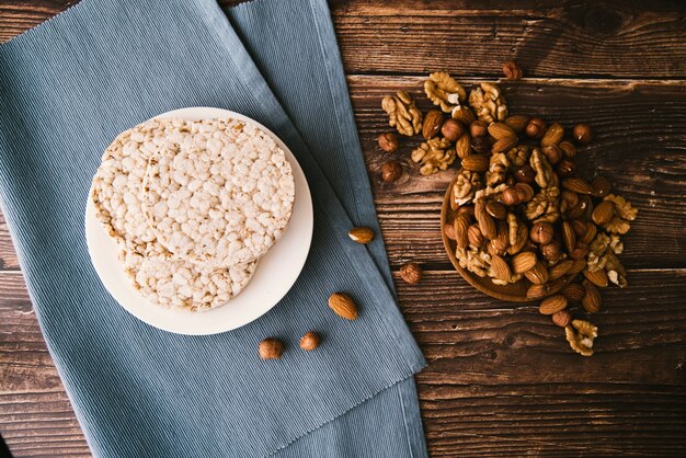 Vista superior de arroz inflado y nueces sobre fondo de madera