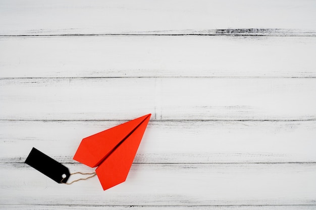 Foto gratuita vista superior del avión de papel rojo con etiqueta sobre fondo de madera