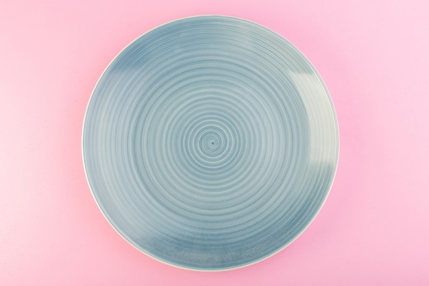 Una vista superior azul placa vacía hecha de vidrio placa para comida en rosa