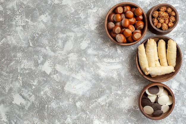 Vista superior de bagels dulces con galletas y nueces sobre superficie blanca