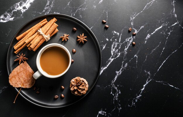 Vista superior de la bandeja con taza de café y palitos de canela