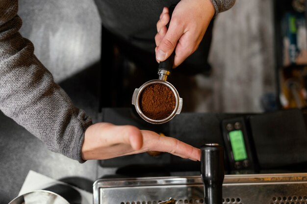 Vista superior del barista masculino con taza de máquina de café profesional