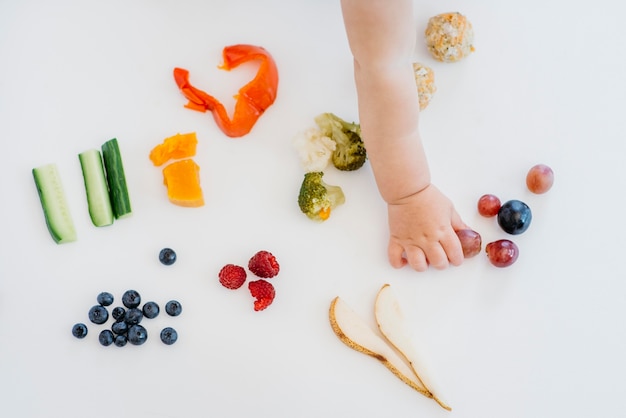 Foto gratuita vista superior del bebé eligiendo qué comer solo