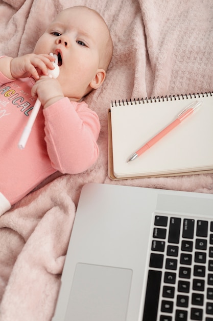 Foto gratuita vista superior del bebé junto a una computadora portátil