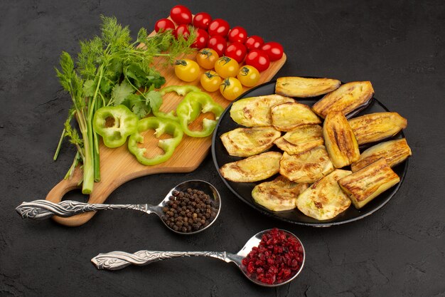 vista superior berenjenas cocidas en rodajas junto con verduras frescas en el piso oscuro