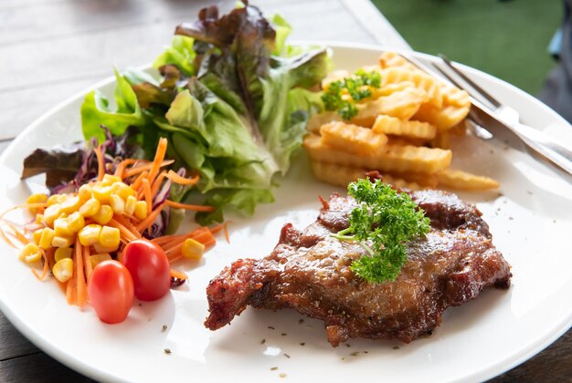 Vista superior del bistec de pollo a la parrilla que se sirve con fuego francés y fotografía de ensalada de verduras