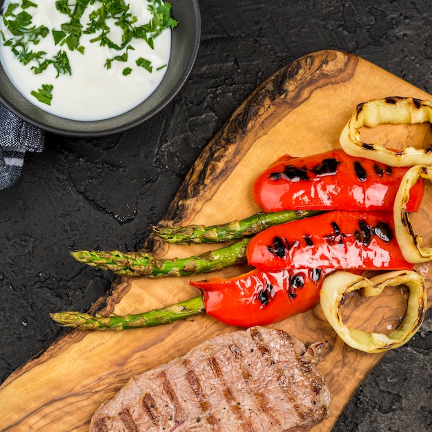 Vista superior de bistec con salsa y verduras