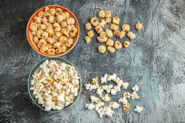 Vista superior bocadillos dulces y salados de palomitas de maíz frescas en superficie ligera