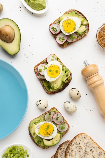 Vista superior de bocadillos con huevo y aguacate junto al plato