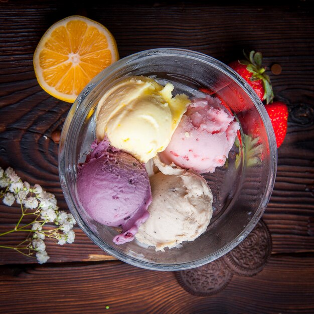 Vista superior bolas de helado con naranja y fresa y naranja y galletas en vaso