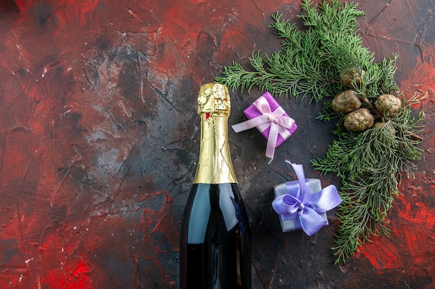 Vista superior botella de champán con regalos en color oscuro beber alcohol foto fiesta de año nuevo