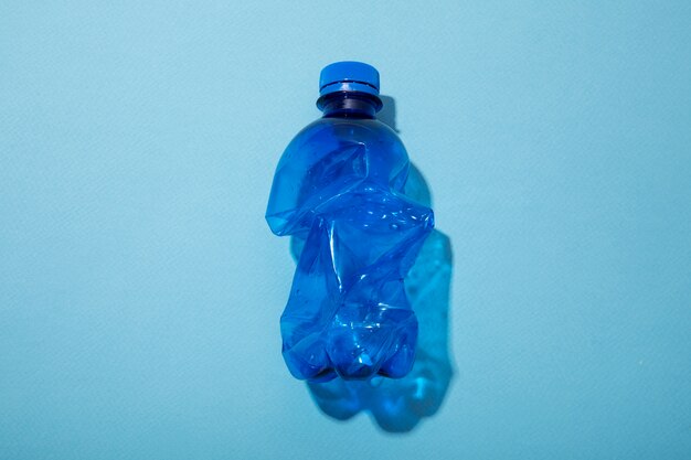 Vista superior botella de plástico sobre fondo azul.