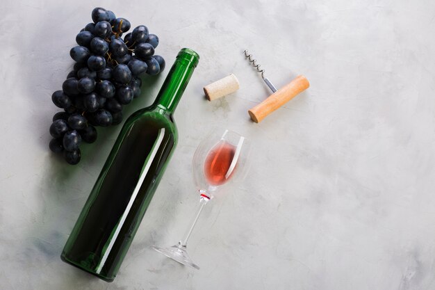 Vista superior botella de vino tinto y uvas